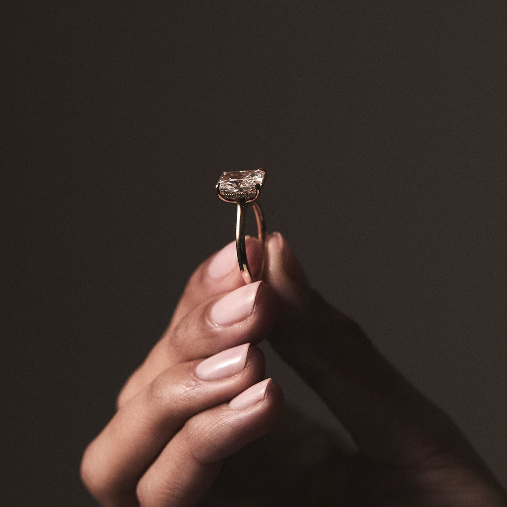hand holding a diamond engagement ring