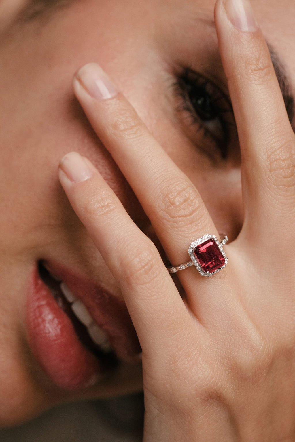 ruby gemstone with diamond halo and sidestones engagement ring
