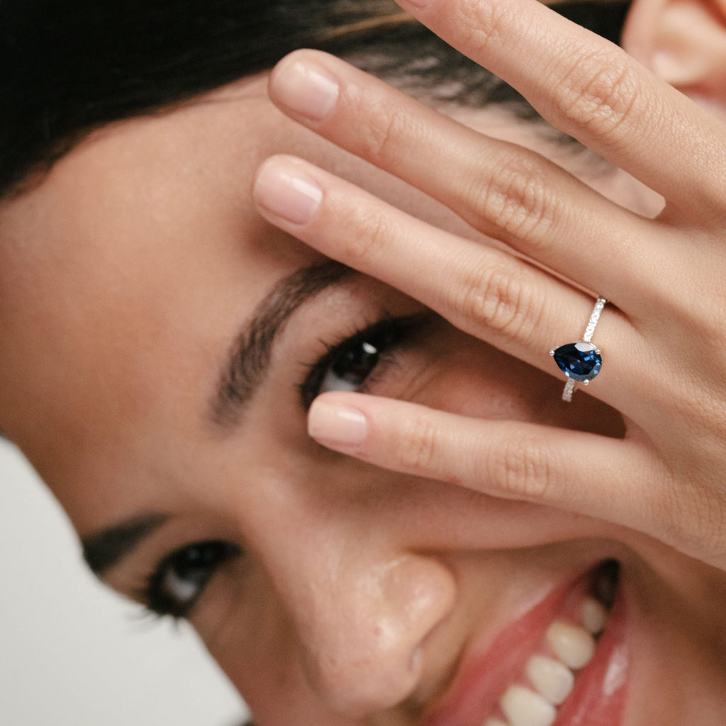 woman wearing pear cut sapphire engagement ring
