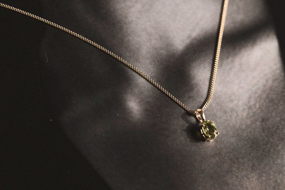 peridot gold pendant necklace over model black and white photograph