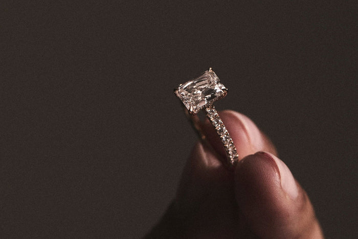 woman holding emerald cut diamond ring
