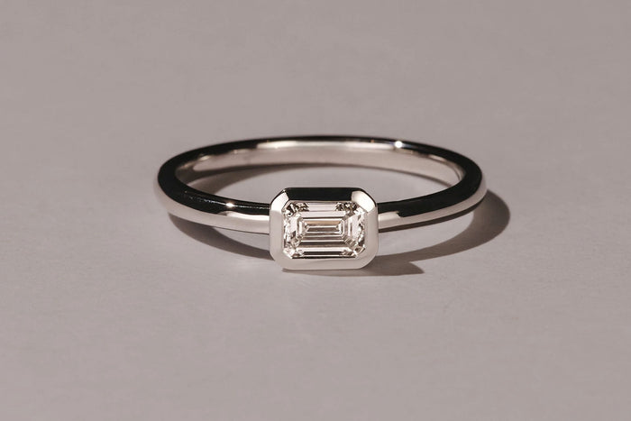 east-west setting emerald cut diamond engagement ring