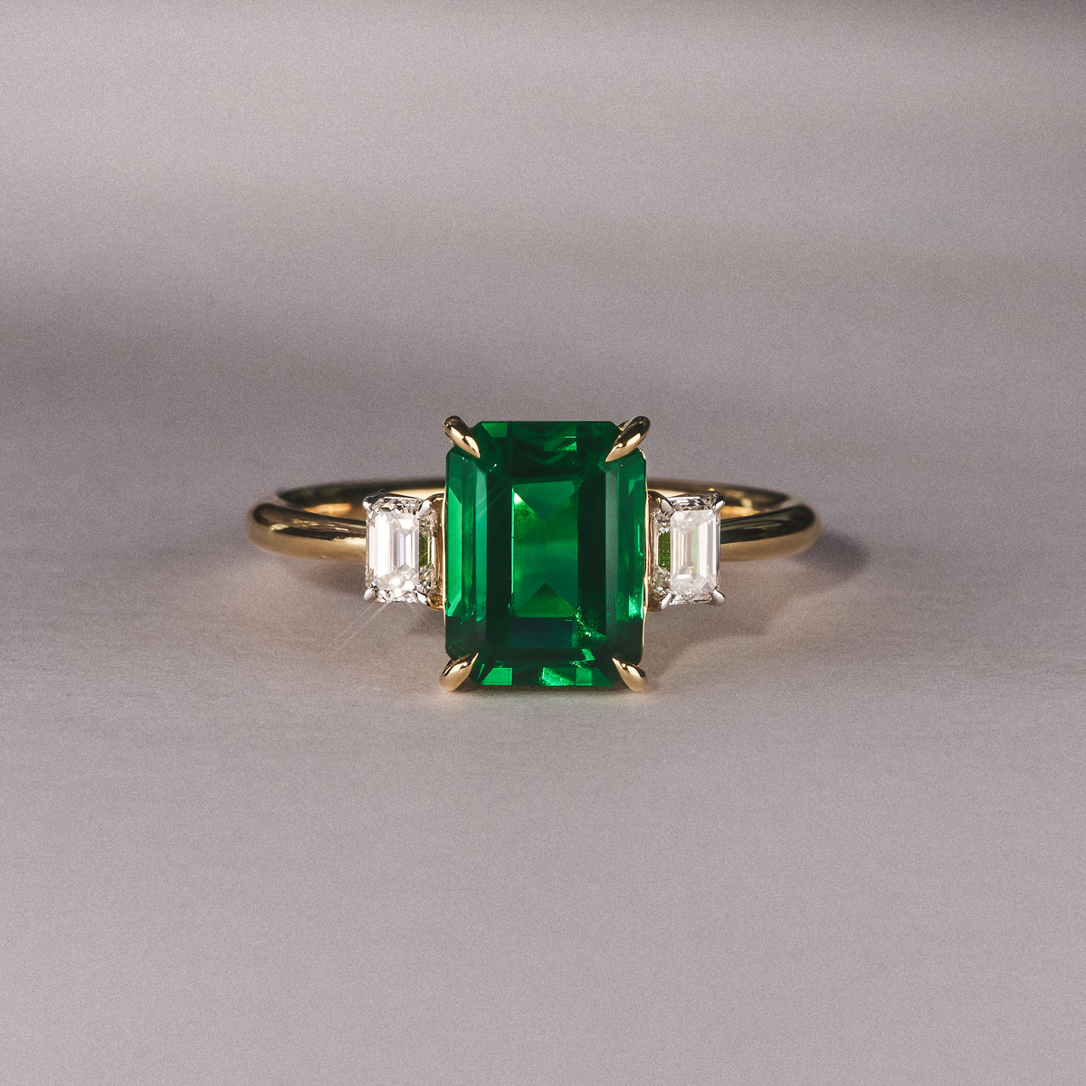 Solene 2.50ct Emerald Cut Lab Emerald and Lab Diamond 3 Stone Engagement Ring in 18K Yellow Gold